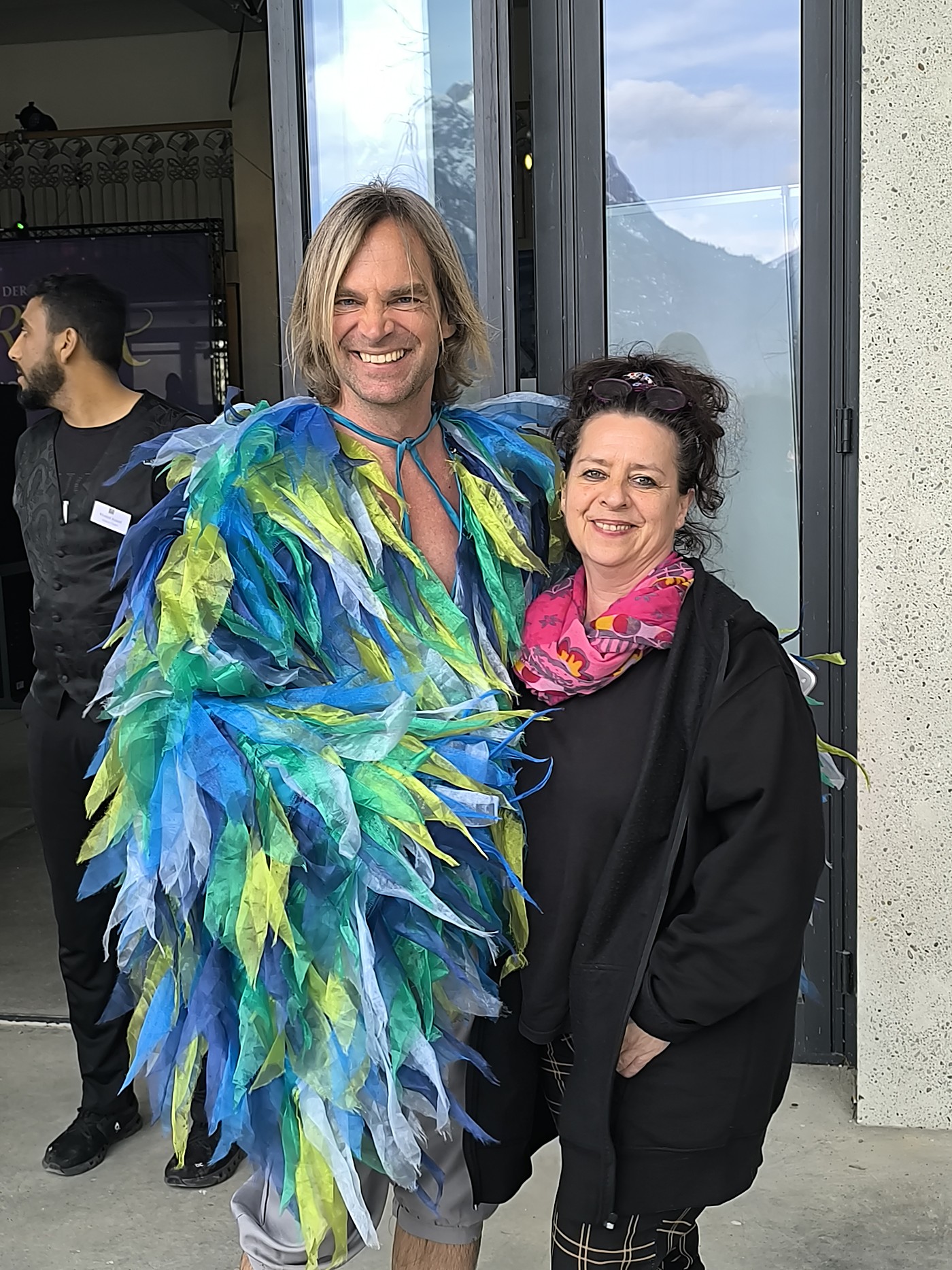 Annette Löchner backstage mit einem Darsteller in einem aufwendigen Federkostüm