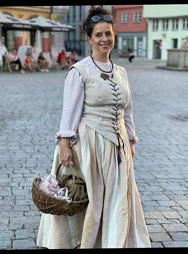 Annette Löchner im historischen Kostüm mit Korb auf einem Marktplatz